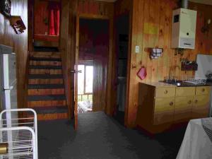 una habitación con cocina y una escalera en una casa en Laguneclub - Su casa de campo, en Frutillar