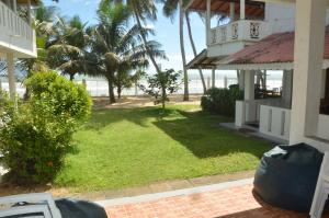 a house with a yard with palm trees and the ocean at Weligama Bay View in Weligama