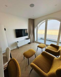 un soggiorno con sedie e TV a schermo piatto di Le One - Villa la Potinière - mer a Dunkerque