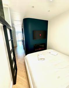 una camera d'albergo con un letto e una tv di Le One - Villa la Potinière - mer a Dunkerque