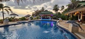 a pool at a resort with dolphins in the water at Sense Asia in Haad Tian