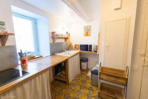 a kitchen with a counter and a sink and a window at Le Havre du Pastre in Buis-les-Baronnies
