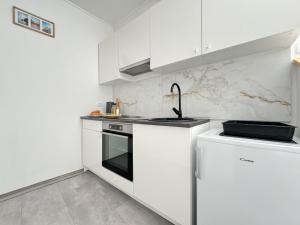 a white kitchen with white cabinets and a sink at Studio Rimac in Dubrovnik