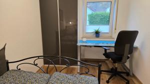 1 dormitorio con escritorio y silla junto a una ventana en Ferienwohnung Schlossblick in Giengen Burgberg, en Giengen an der Brenz