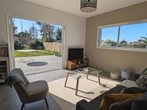 a living room with a couch and a tv at Maison familiale avec jardin a deux pas de l'océan in Préfailles