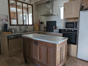 a kitchen with a island in the middle of it at Les pierres qui parlent in Précilhon