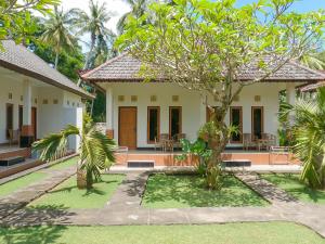a house with a courtyard and trees in front of it at Maja House Penida in Nusa Penida
