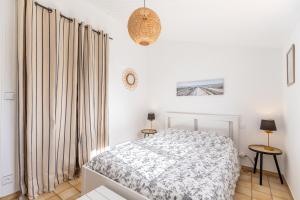 a white bedroom with a bed and curtains at Le 5 Mimosas - Plage à 600m garage in Saint-Jean-de-Monts