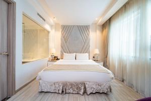 a bedroom with a large bed and a shower at Nicecy Hotel Suites & Spa in Ho Chi Minh City