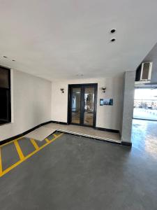 a empty room with yellow lines on the floor at Three Bedrooms Smart Access Compound - شقة انيقة ثلاث غرف كمباوند مدخل ذكي in Dammam