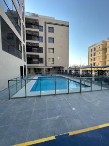 a swimming pool in front of a building at Three bedrooms compound - شقة انيقة ثلاث غرف كمباوند in Dammam