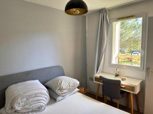 a bedroom with a bed and a desk and a window at L'Eclat Terrasse - Piscine - Tennis in Ondres +23 photos