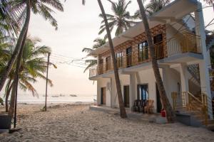 a house on the beach with palm trees at Om Atharva Beach Homestay Malvan in Malvan