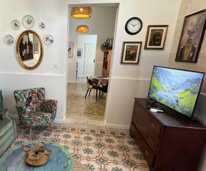un soggiorno con TV su un comò di Central Boutique Apartment Near Valletta with Cafeteria Just Next Door - Perfect for Couples Wanting to Discover Malta - Bus Stops Just Outside a Msida