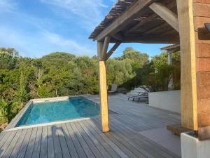 a house with a swimming pool on a wooden deck at suara in Pinarellu