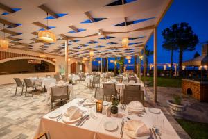 a restaurant with white tables and chairs and lights at Gravel Hotels Select - Ultra All Inclusive in Kemer