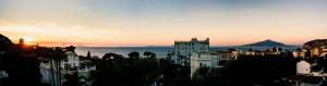 a view of a city at sunset with a mountain at Hotel Crawford in Sant'Agnello