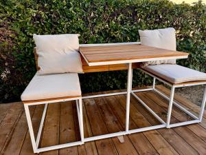 a picnic table and two chairs on a deck at La Suite romantique des Chatons in Mimizan