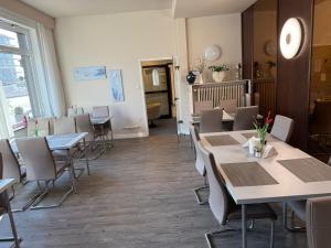 ein Restaurant mit Tischen und Stühlen in einem Raum in der Unterkunft Hotel Erlenstegen in Nürnberg