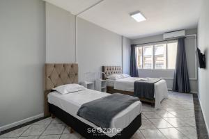 フロリアノポリスにあるEJO - Apartamentos Modernos no Centro de Floripaのベッドが2つと窓があるホテルの部屋