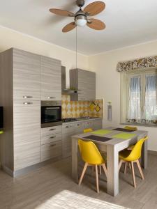 a kitchen with a dining table and yellow chairs at Casa Vacanze Magistro in Patti