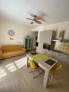 a kitchen and living room with a table and yellow chairs at Casa Vacanze Magistro in Patti