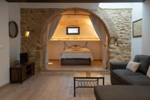 a living room with a bed in a stone wall at Can Joan Loft Alt Empordà in Ordis +16 photos