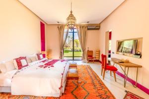 a bedroom with a bed and a table and a desk at The Source Hotel Music & Spa in Marrakesh