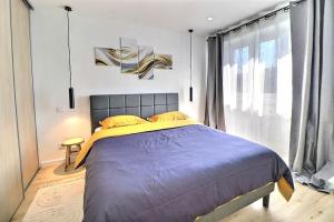 a bedroom with a large bed and a large window at Appartement Moderne et Cosy avec Balcon - Parking Gratuit - Netflix in Logelbach