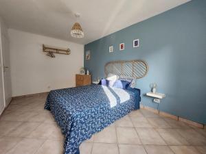 a bedroom with a bed and a blue wall at Le calme à la mer - Maison familiale avec jardin in Équihen-Plage