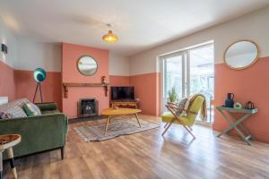 un salon avec un canapé vert et des chaises dans l'établissement Sanderlings by Winterton Cottages, à Winterton-on-Sea