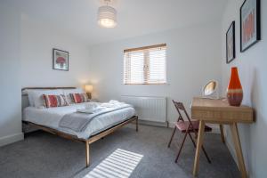 une chambre avec un lit, une table et un bureau dans l'établissement Sanderlings by Winterton Cottages, à Winterton-on-Sea