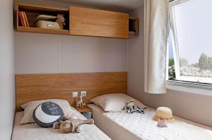 a small bedroom with two beds with stuffed animals on them at Camping maeva Escapades Country Park - Touquin in Touquin +36 photos