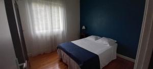 a bedroom with a bed with blue walls and a window at La Vie Autrement - Maison à la campagne in Claracq