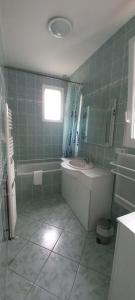 a bathroom with a tub and a sink and a bath tub at La Vie Autrement - Maison à la campagne in Claracq +8 photos