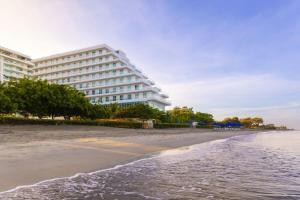 a hotel on the beach next to the ocean at Santa Marta Marriott Resort Playa Dormida in Santa Marta