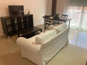 a living room with a white couch and a table at Apartamento Cumbre in San Sebastián de la Gomera +1 photo