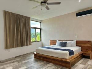 a bedroom with a bed with a ceiling fan and a window at Hotel Piedra del Caribe Puerto Morelos in Puerto Morelos +27 photos