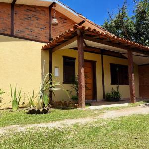 a yellow house with a brown door and grass at Pousada Mirante da Lua in Lavras Novas +42 photos
