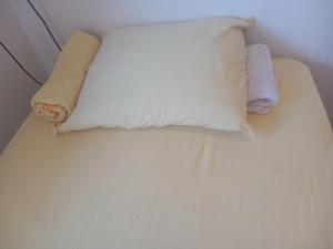 Una cama con dos almohadas y dos toallas encima. en Apartman MDj, en Žarkovo