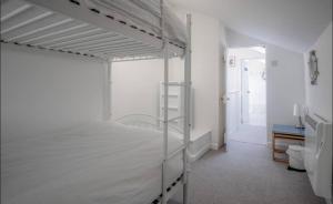 a white bedroom with a bunk bed and a bathroom at Calebs Cottage- Solva harbour in Solva +52 photos