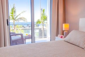 a bedroom with a bed and a view of a balcony at Madeira Beach House by Atlantic Holiday in Madalena do Mar +29 photos