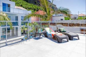 a patio with two chairs and a table on a balcony at Madeira Beach House by Atlantic Holiday in Madalena do Mar
