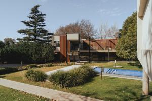 a building with a swimming pool in a park at La Urumpta Hotel, AKEN MIND in Río Cuarto