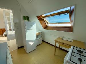 a kitchen with a refrigerator and a table and a window at MOUETTES 3 - Balcon, Vue Mer, Men Du - T356 in Carnac