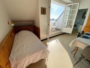 a small bedroom with a bed and a balcony at MOUETTES 3 - Balcon, Vue Mer, Men Du - T356 in Carnac