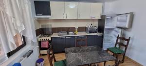 a small kitchen with a stove and a refrigerator at Casa Sava in Letea Veche