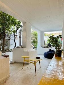 Zimmer mit einem gelben Tisch und einer Bank in der Unterkunft La maison de oiseaux in Salambôo