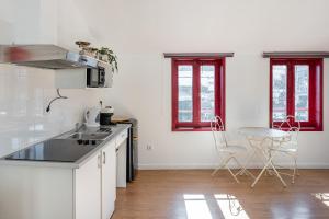 a kitchen with white appliances and red windows at GuestReady - Oporto Old Town House 3 in Porto