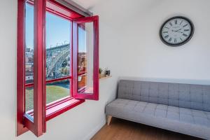 a room with a couch and a clock and a window at GuestReady - Oporto Old Town House 3 in Porto +19 photos